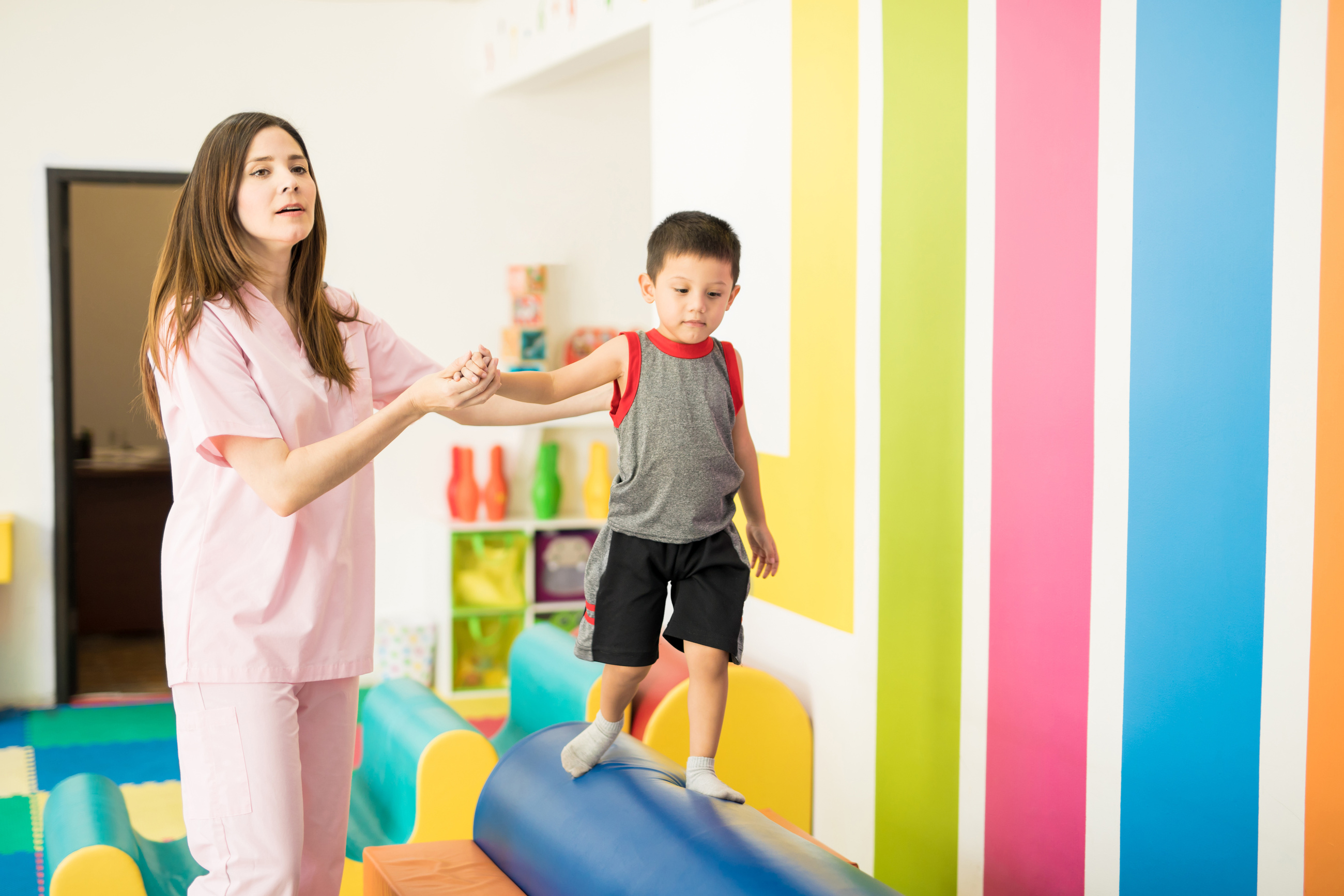 Therapist helping a kid with balance